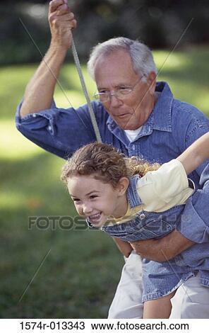 Granddaughter sitting on her grandfather's lap swinging on a swing View Large Photo Image Stock Image - Granddaughter sitting on her grandfather's lap swinging on a swing. Fotosearch