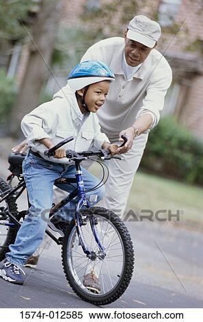 Grandfather teaching his grandson ride a bicycle View Large Photo Image Stock Photography - Grandfather teaching his grandson ride a bicycle. Fotosearch