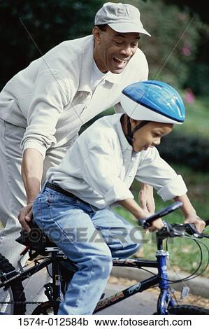 Grandfather teaching his grandson to ride a bicycle View Large Photo Image Stock Image - Grandfather teaching his grandson to ride a bicycle. Fotosearch