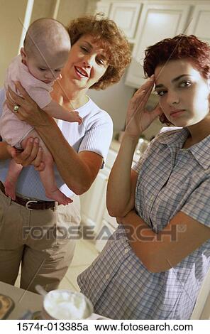 Grandmother holding her granddaughter with her daughter standing beside her View Large Photo Image Stock Image - Grandmother holding her granddaughter with her daughter standing beside her. Fotosearch