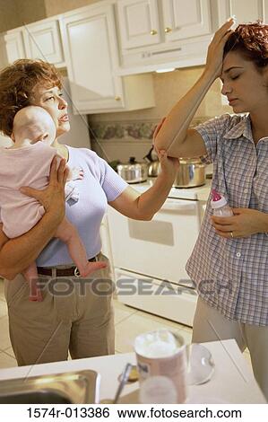 Stock Photograph - Grandmother holding her granddaughter and talking to her daughter. Fotosearch