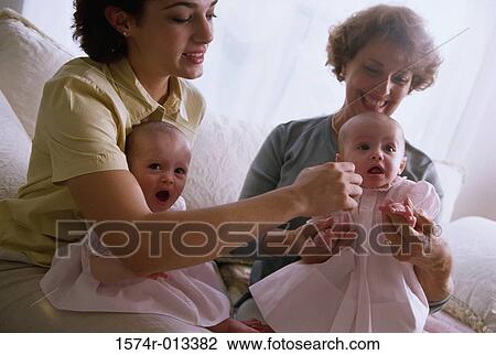 Stock Image - Grandmother smiling with her daughter and two granddaughters. Fotosearch