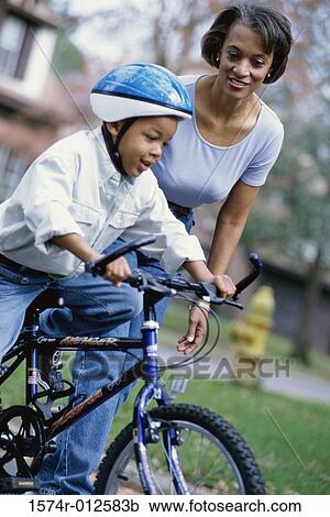 Grandmother teaching her grandson to ride a bicycle View Large Photo Image Stock Image - Grandmother teaching her grandson to ride a bicycle. Fotosearch