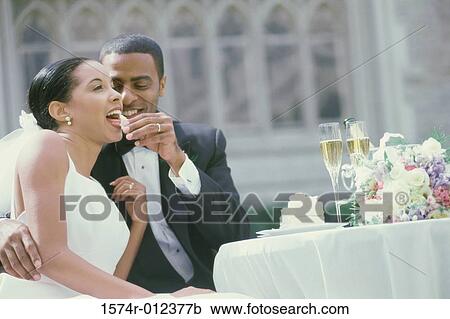 Groom feeding a piece of a cake to his bride View Large Photo Image Stock Image - Groom feeding a piece of a cake to his bride. Fotosearch
