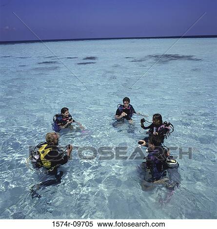 Stock Photography - Group of people with scuba gear in the sea. Fotosearch