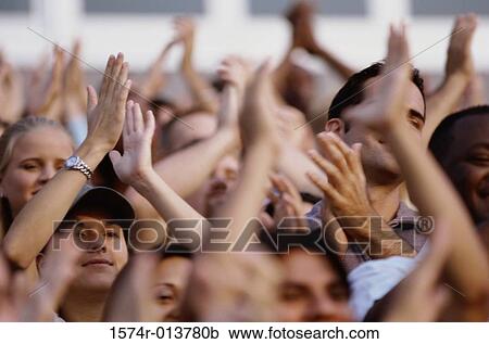 Stock Image - Group of spectators applauding in a stadium. Fotosearch