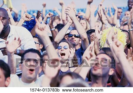 Stock Image - Group of spectators applauding in a stadium. Fotosearch