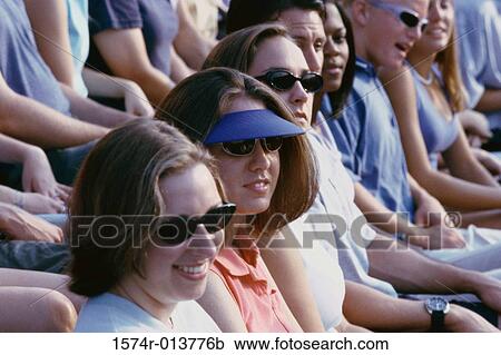 Group of spectators sitting in a stadium View Large Photo Image Stock Image - Group of spectators sitting in a stadium. Fotosearch