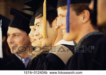 Stock Image - Group of young graduates standing together. Fotosearch