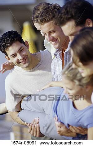 Stock Image - Group of young men carrying a young woman. Fotosearch