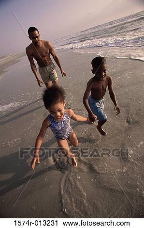 High angle view of a brother and sister running on the beach View Large Photo Image Stock Image - High angle view of a brother and sister running on the beach. Fotosearch