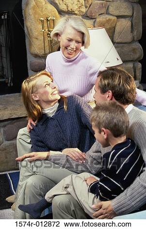 Stock Image - High angle view of a family sitting in a living room. Fotosearch