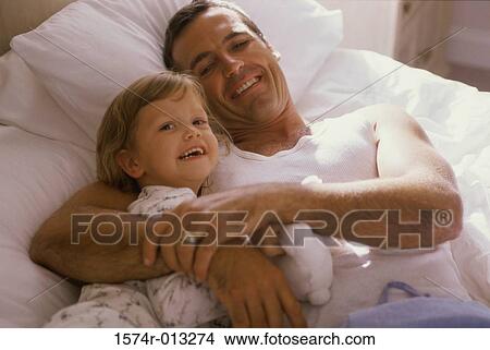 High angle view of a father hugging his daughter in bed View Large Photo Image Picture - High angle view of a father hugging his daughter in bed. Fotosearch