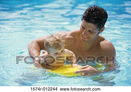 High angle view of a father teaching his son to swim View Large Photo Image Picture - High angle view of a father teaching his son to swim. Fotosearch