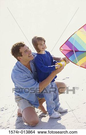 Picture - High angle view of a father teaching his daughter to fly a kite. Fotosearch
