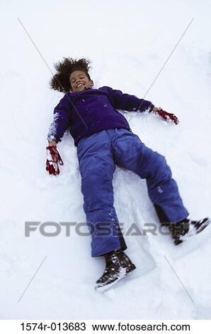 High angle view of a girl lying down in snow making a snow angel View Large Photo Image Stock Image - High angle view of a girl lying down in snow making a snow angel. Fotosearch