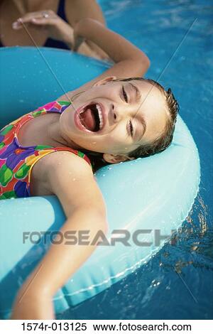 High angle view of a girl lying on an inflatable ring in a swimming pool View Large Photo Image Stock Photography - High angle view of a girl lying on an inflatable ring in a swimming pool. Fotosearch