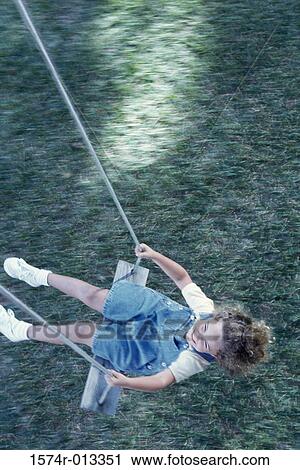 High angle view of a girl swinging on a swing View Large Photo Image Stock Image - High angle view of a girl swinging on a swing. Fotosearch