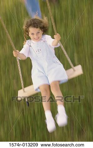 High angle view of a girl swinging on a swing View Large Photo Image Stock Photo - High angle view of a girl swinging on a swing. Fotosearch