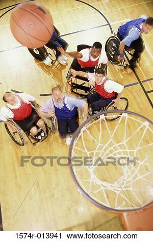 Stock Image - High angle view of a group of mid adult men in wheelchairs playing basketball. Fotosearch