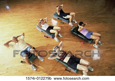 Stock Image - High angle view of a group of people exercising in a step aerobics class. Fotosearch