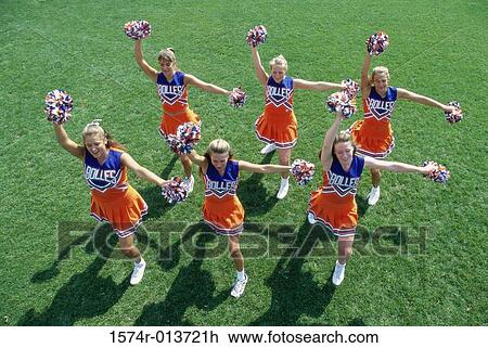 Stock Image - High angle view of a group of cheerleaders cheering in a field. Fotosearch