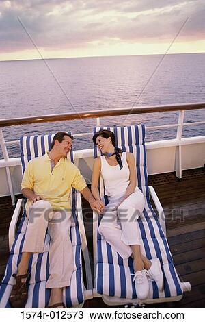 High angle view of a mid adult couple reclining in lounge chairs View Large Photo Image Stock Image - High angle view of a mid adult couple reclining in lounge chairs. Fotosearch