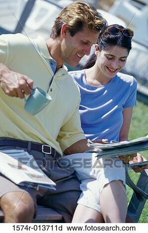 Stock Image - High angle view of a mid adult couple reading a newspaper. Fotosearch