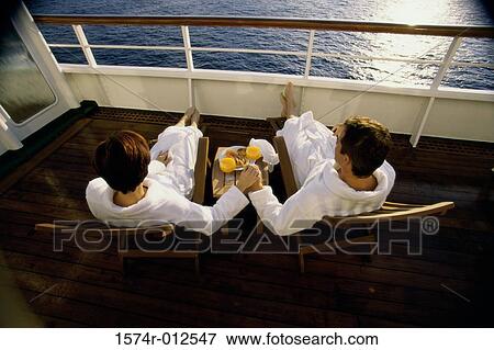 High angle view of a mid adult couple sitting in deck chairs on a cruise ship View Large Photo Image Stock Photo - High angle view of a mid adult couple sitting in deck chairs on a cruise ship. Fotosearch