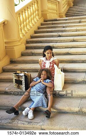 High angle view of a mother and daughter sitting on steps View Large Photo Image Stock Image - High angle view of a mother and daughter sitting on steps. Fotosearch