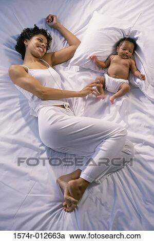 High angle view of a mother playing with her son on a bed View Large Photo Image Stock Image - High angle view of a mother playing with her son on a bed. Fotosearch