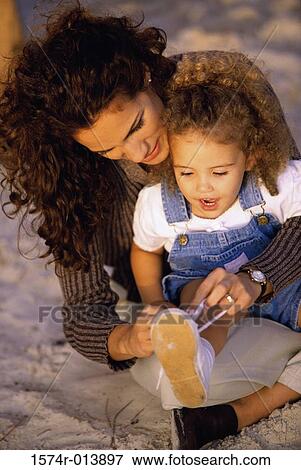 High angle view of a mother tying shoelaces for her daughter View Large Photo Image Stock Photo - High angle view of a mother tying shoelaces for her daughter. Fotosearch