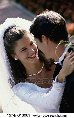 Stock Image - High angle view of a newlywed couple embracing each other. Fotosearch