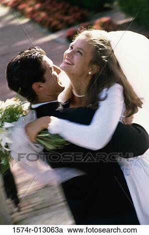 Stock Image - High angle view of a newlywed couple embracing each other. Fotosearch