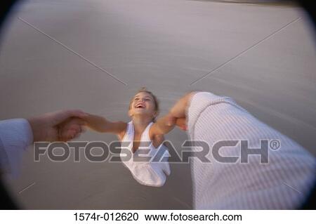 High angle view of a person's hands swinging a girl on the beach View Large Photo Image Stock Image - High angle view of a person's hands swinging a girl on the beach. Fotosearch