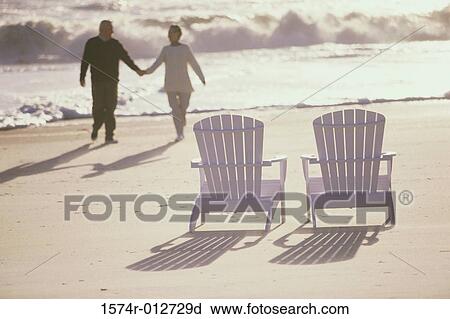 Stock Image - High angle view of a senior couple walking together on the beach. Fotosearch