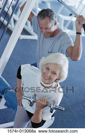 Stock Image - High angle view of a senior couple exercising in a gym. Fotosearch
