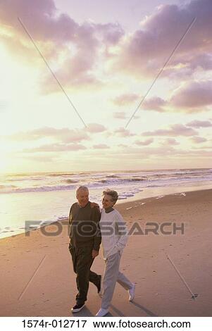 Stock Photo - High angle view of a senior couple walking together on the beach. Fotosearch