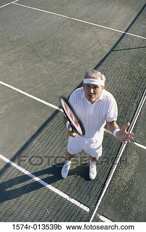 High angle view of a senior man gesturing on a tennis court View Large Photo Image Stock Image - High angle view of a senior man gesturing on a tennis court. Fotosearch