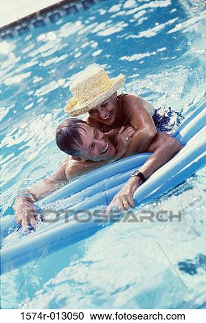 High angle view of a senior woman embracing a senior man from behind in a swimming pool View Large Photo Image Stock Image - High angle view of a senior woman embracing a senior man from behind in a swimming pool. Fotosearch