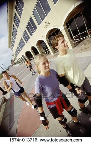 High angle view of a teenage couple skating on the road View Large Photo Image Stock Photograph - High angle view of a teenage couple skating on the road. Fotosearch