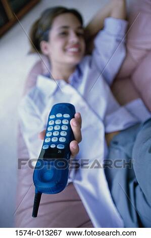 High angle view of a teenage girl lying on a couch showing a cordless phone View Large Photo Image Stock Photo - High angle view of a teenage girl lying on a couch showing a cordless phone. Fotosearch
