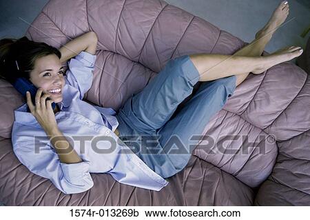 High angle view of a teenage girl resting on a couch talking on a phone View Large Photo Image Stock Image - High angle view of a teenage girl resting on a couch talking on a phone. Fotosearch