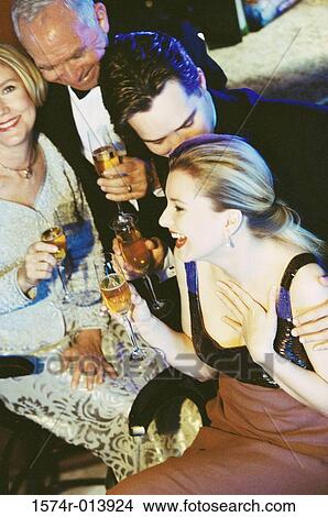 High angle view of a young couple and senior couple holding glasses of champagne at a bar View Large Photo Image Picture - High angle view of a young couple and senior couple holding glasses of champagne at a bar. Fotosearch