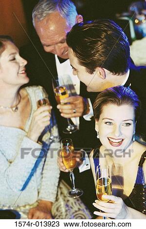 High angle view of a young couple and senior couple holding glasses of champagne at a bar View Large Photo Image Stock Image - High angle view of a young couple and senior couple holding glasses of champagne at a bar. Fotosearch