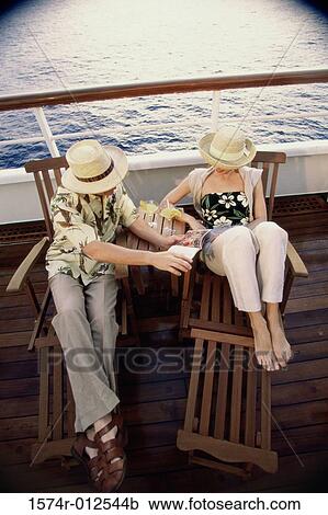 High angle view of a young couple sitting in deck chairs on a cruise ship View Large Photo Image Stock Image - High angle view of a young couple sitting in deck chairs on a cruise ship. Fotosearch