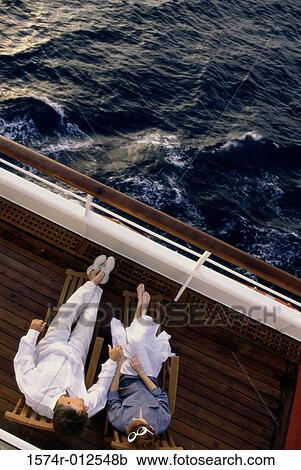 High angle view of a young couple sitting on deck chairs on a cruise ship View Large Photo Image Stock Image - High angle view of a young couple sitting on deck chairs on a cruise ship. Fotosearch