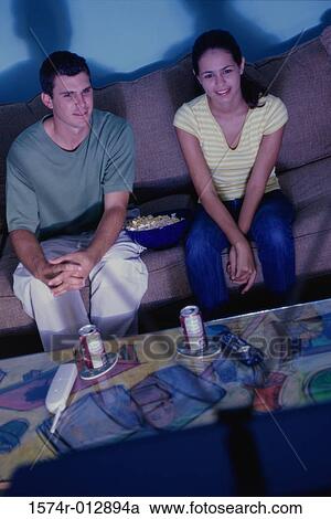 High angle view of a young couple watching television View Large Photo Image Stock Image - High angle view of a young couple watching television. Fotosearch