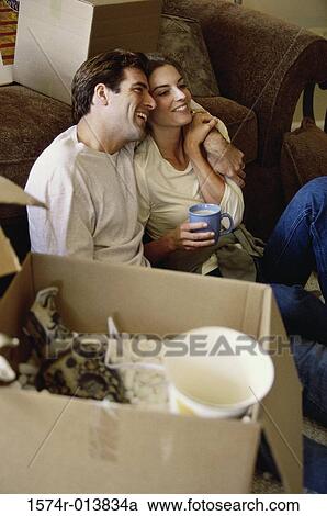 High angle view of a young couple smiling near cardboard boxes View Large Photo Image Stock Image - High angle view of a young couple smiling near cardboard boxes. Fotosearch