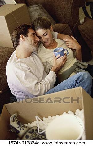Stock Image - High angle view of a young couple holding a cup of coffee. Fotosearch